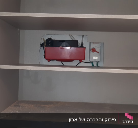 ארון עם מדפים, כלי עבודה אדום ומתג חשמלי